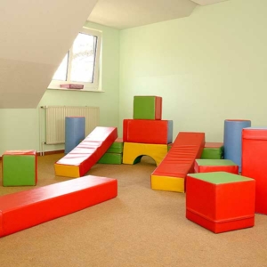 Der Bewegungsraum der Kita Wittekstraße mit vielen farbenfrohen stapelbaren Elementen zum Draufrumturnen.